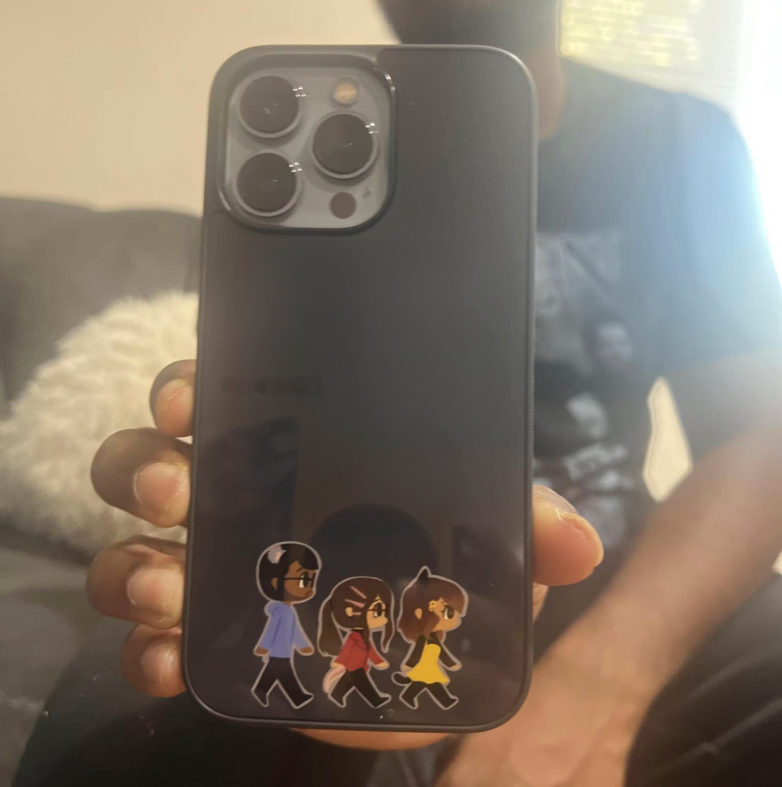 a boy holding a custom iphone case that has a picture of characters walking.